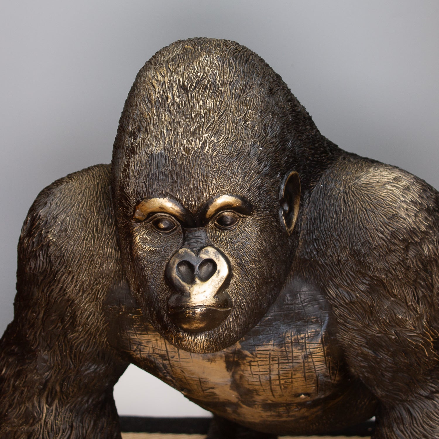 Bronze statue of a gorilla on a gray background